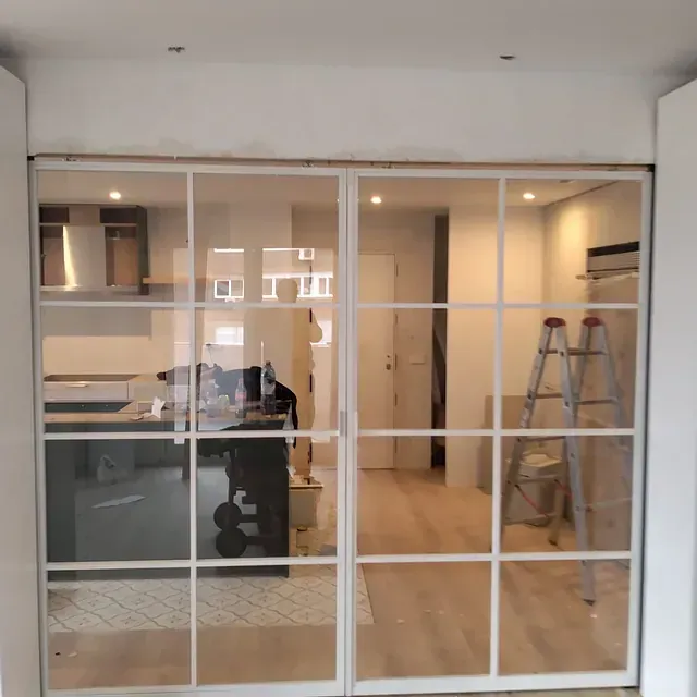 Una cocina con puertas corredizas de vidrio y una escalera.