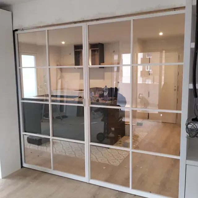 Una habitación con muchas ventanas y una puerta corrediza de vidrio.