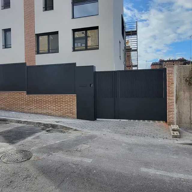 Un edificio con una puerta negra delante.