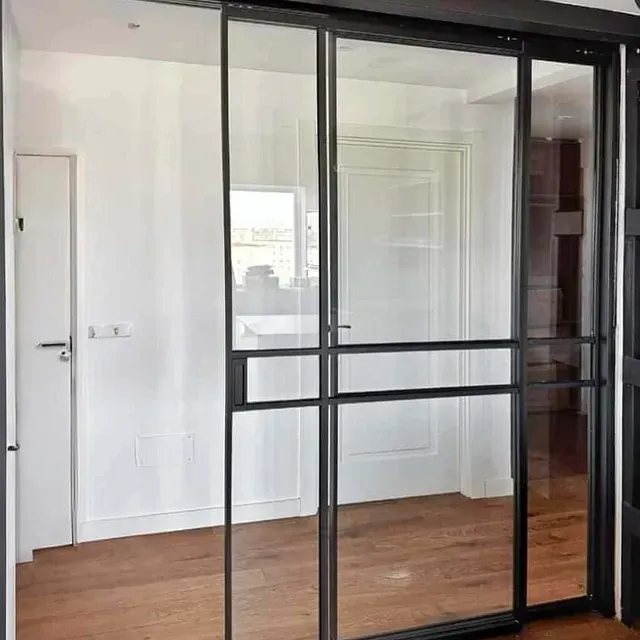 Una habitación con puertas corredizas de vidrio y piso de madera.