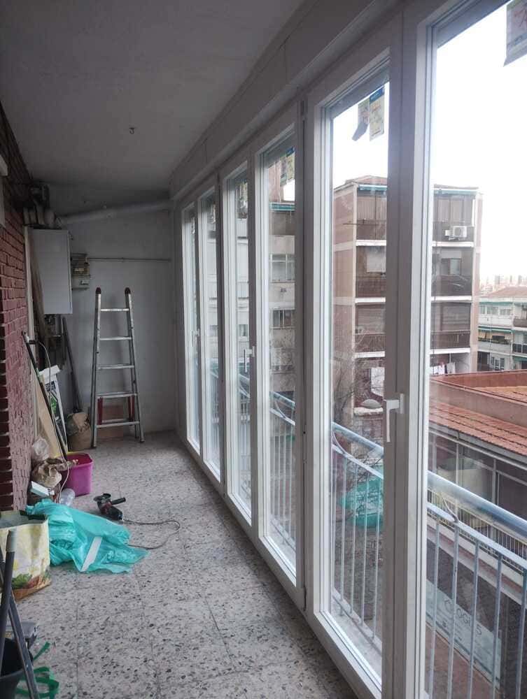 Una habitación grande con muchas ventanas y una escalera.