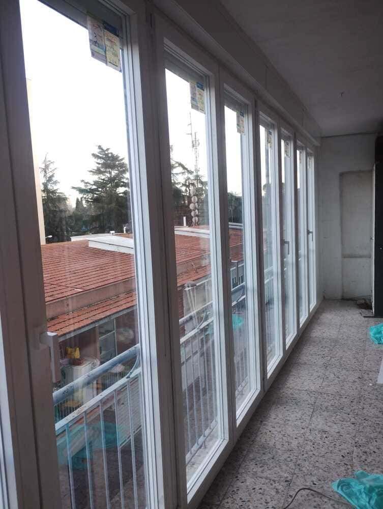 Una habitación con muchas ventanas y balcón.