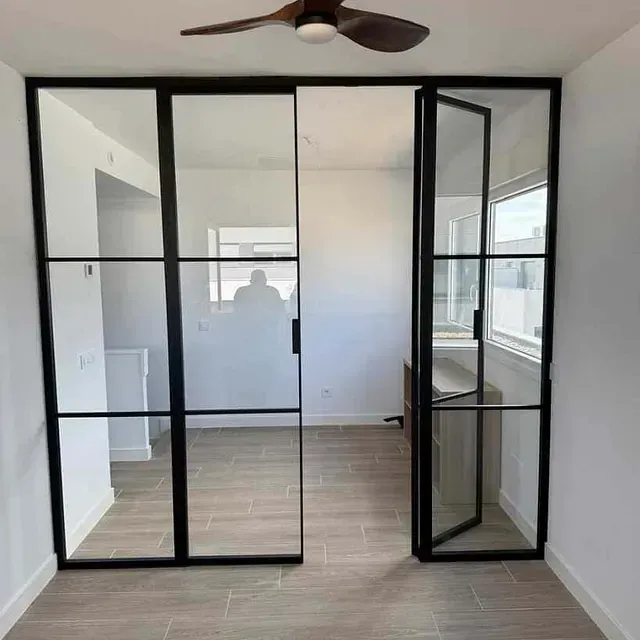 Una habitación con puertas corredizas de vidrio y un ventilador de techo.
