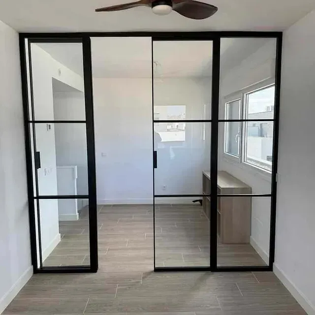 Una habitación con puertas corredizas de vidrio y un ventilador de techo.