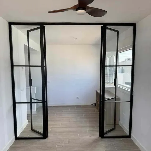 Una habitación con puertas corredizas de vidrio y un ventilador de techo.