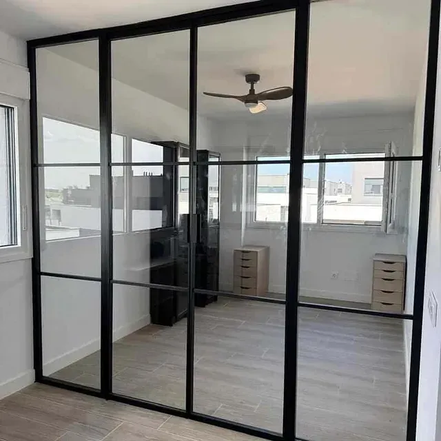 Una habitación con puertas corredizas de vidrio y un ventilador de techo.