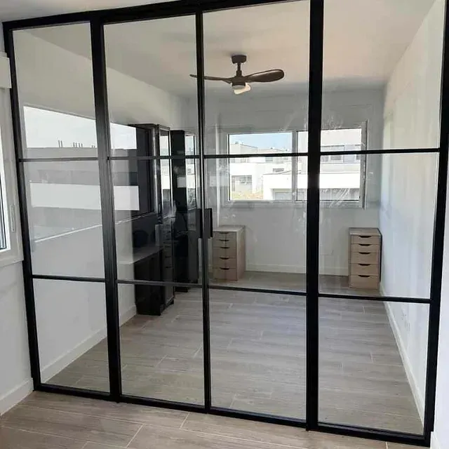 Una habitación con puertas corredizas de vidrio y un ventilador de techo.