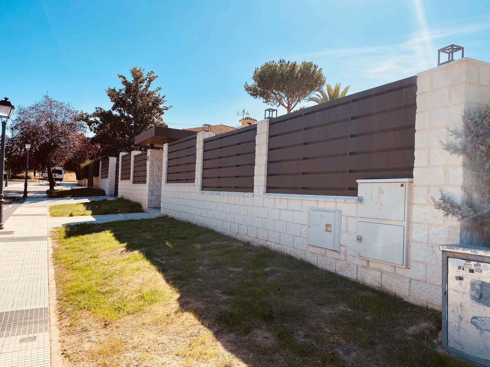 Una pared de ladrillos con una valla de madera que la rodea.