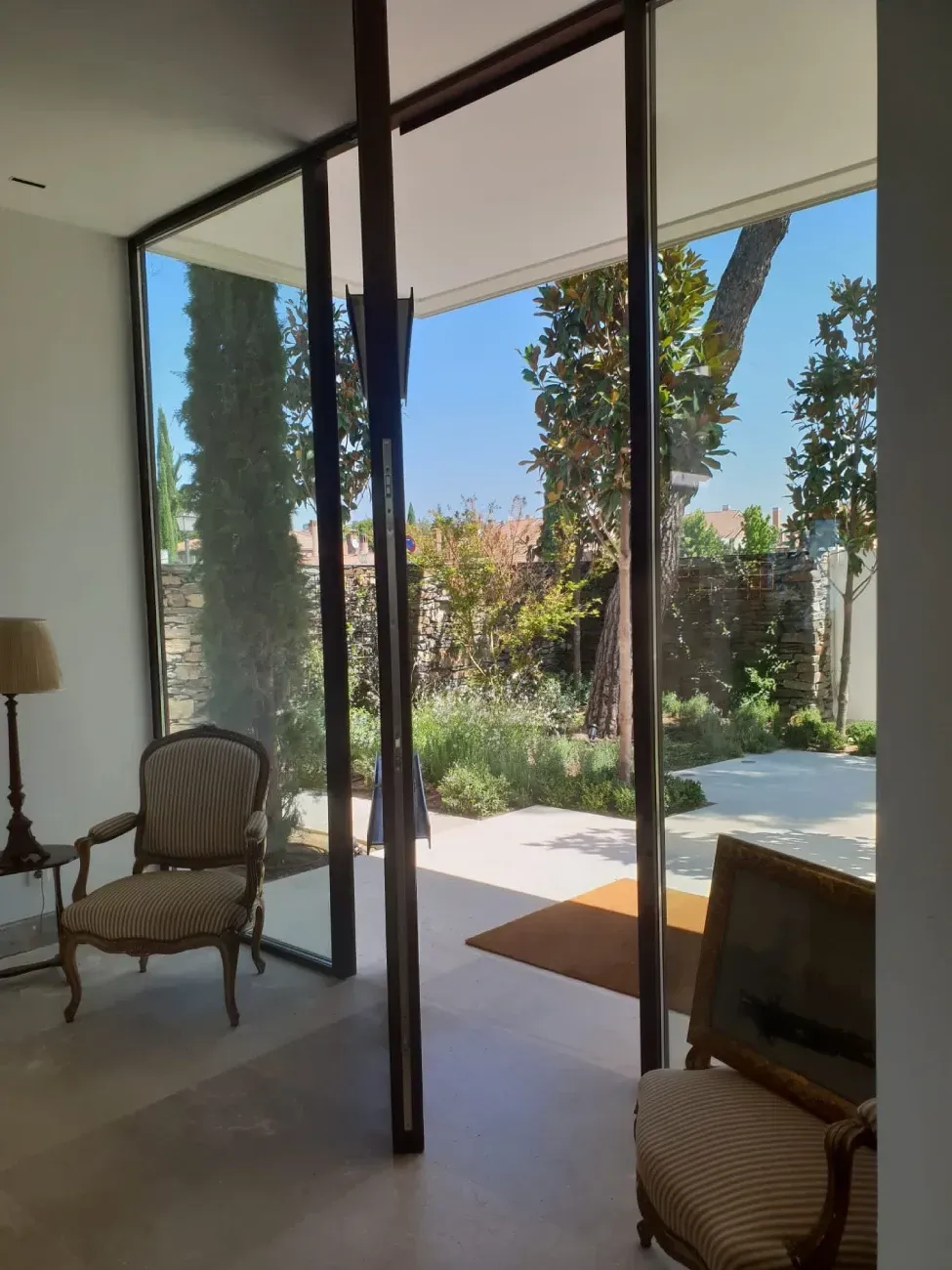 Una sala de estar con una silla y una lámpara.