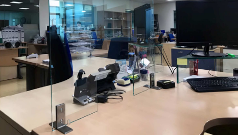 Un escritorio con una computadora y un teléfono encima en una oficina.