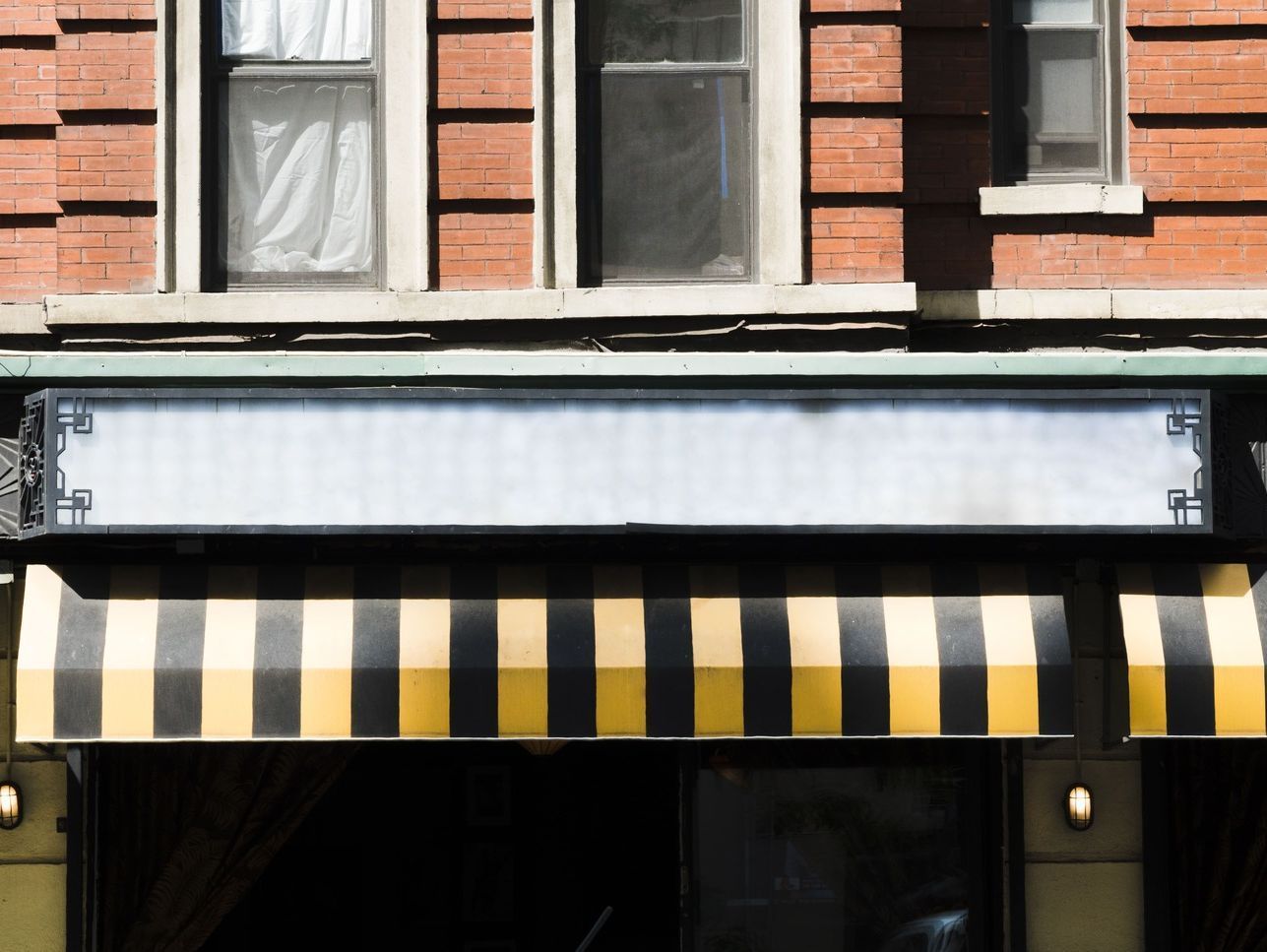 Un toldo negro y amarillo está en el frente de un edificio.