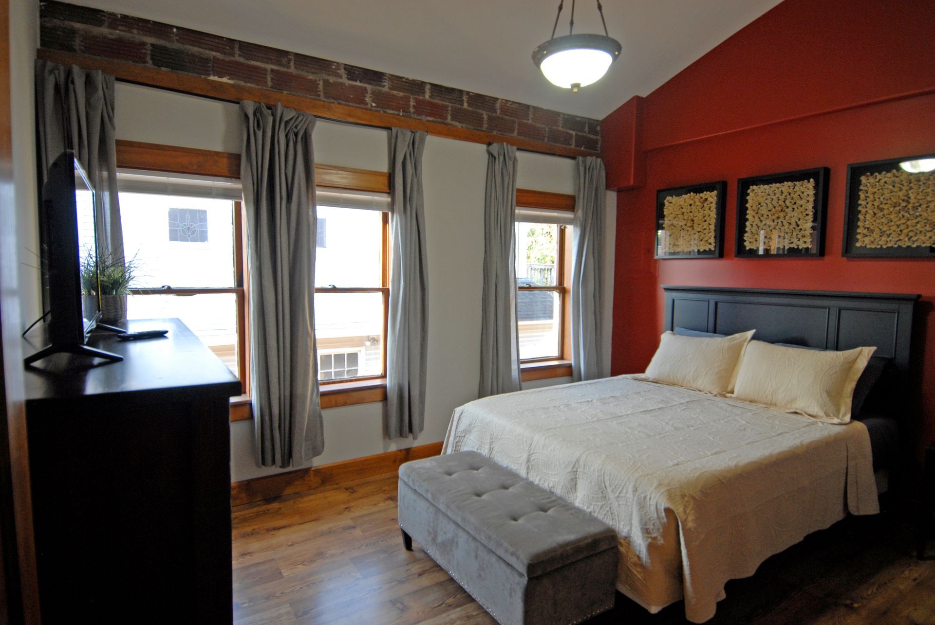 A bedroom with a king size bed and a dresser