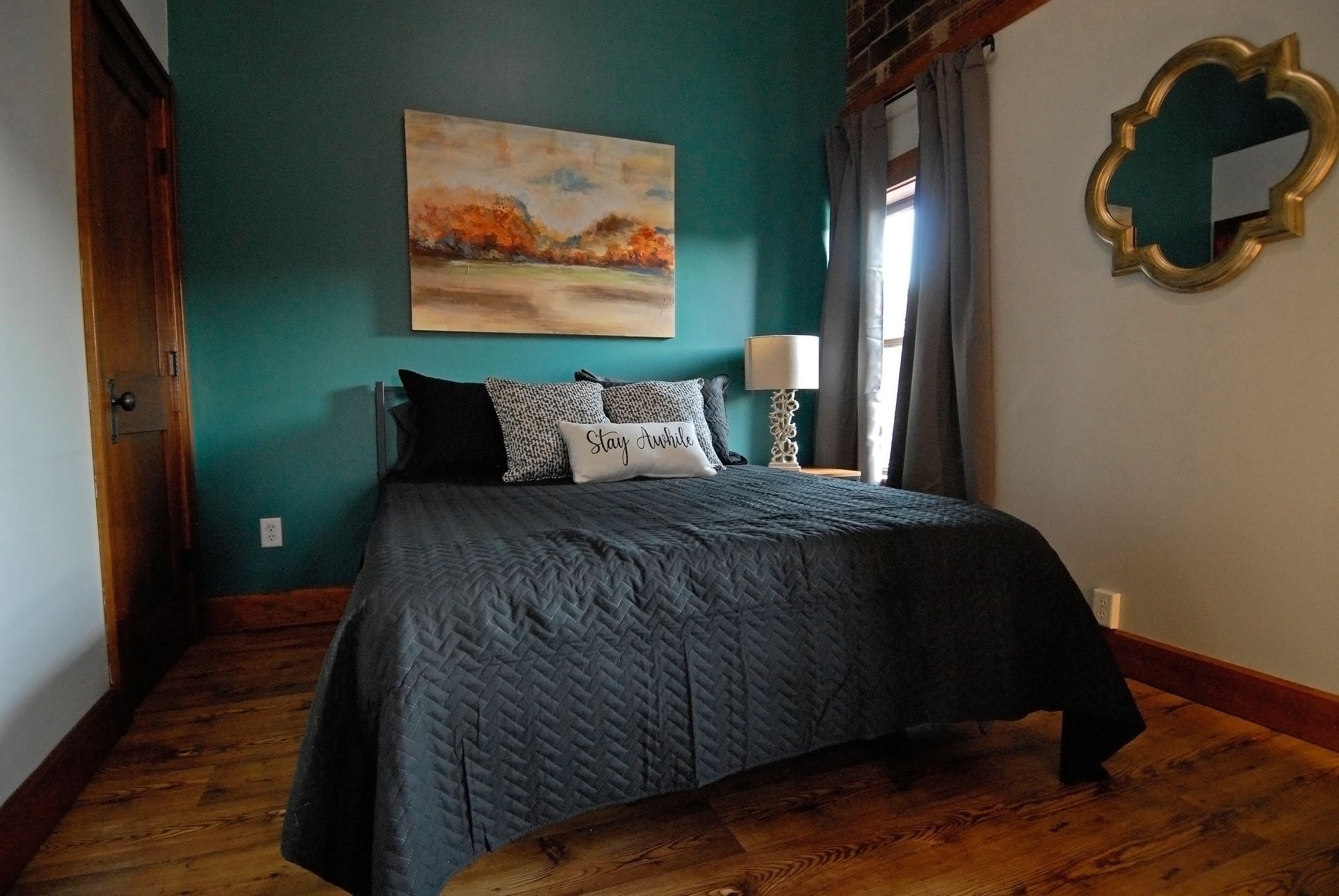 A bedroom with a bed and a painting on the wall