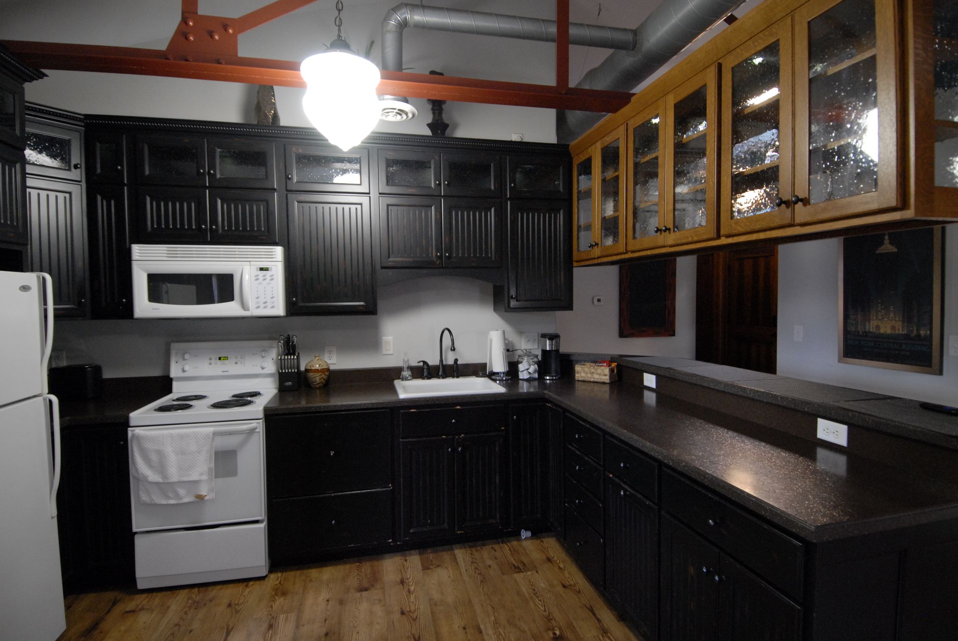 A kitchen with black cabinets and white appliances