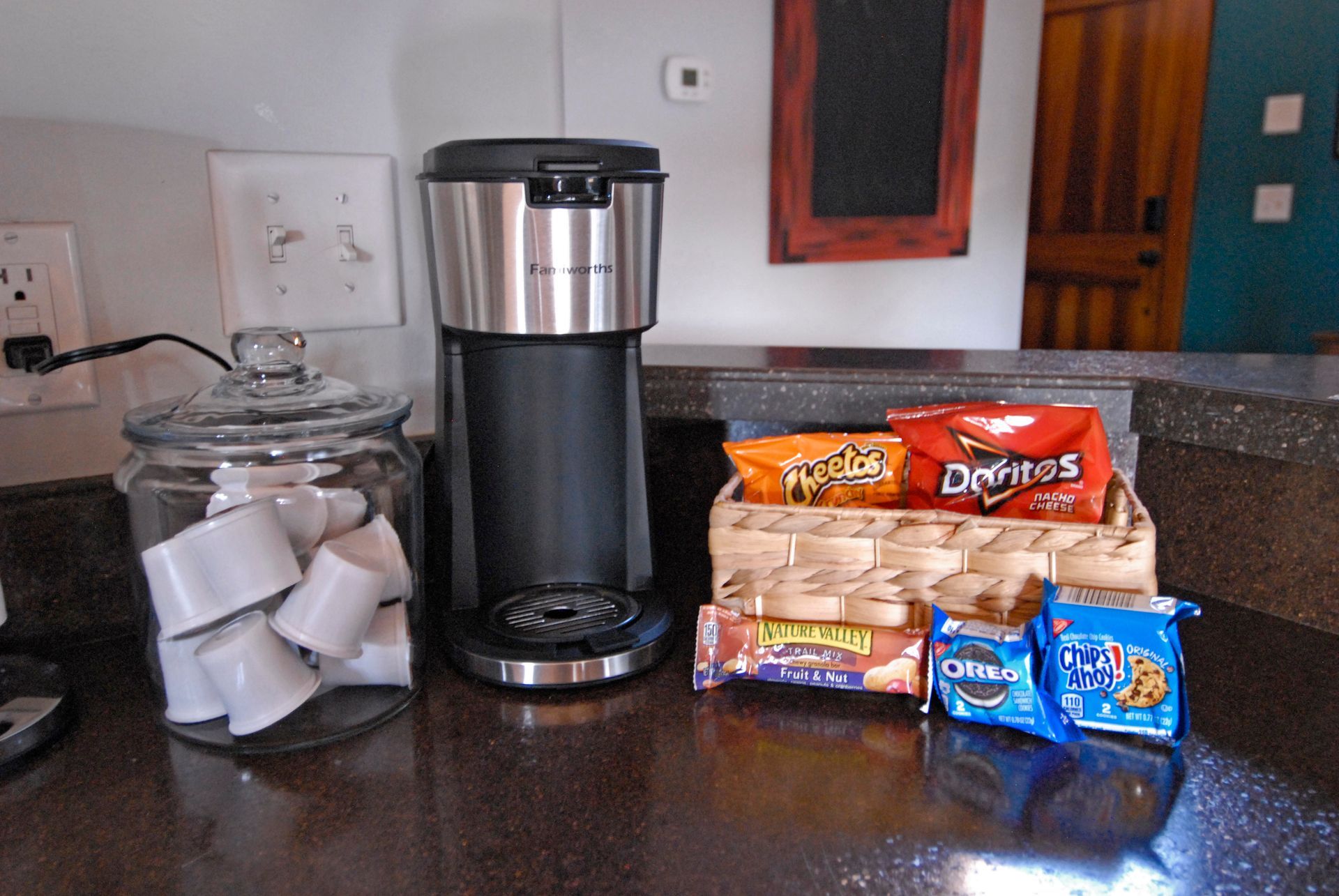A kitchen counter with a coffee maker and snacks including doritos