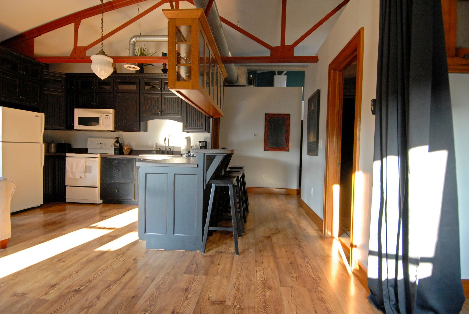 A kitchen with hardwood floors and a white refrigerator