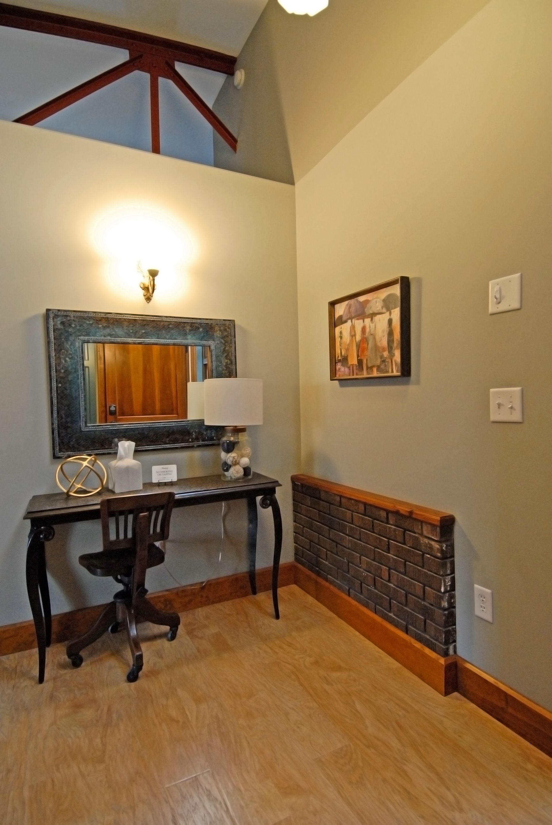 A room with a desk and a mirror on the wall