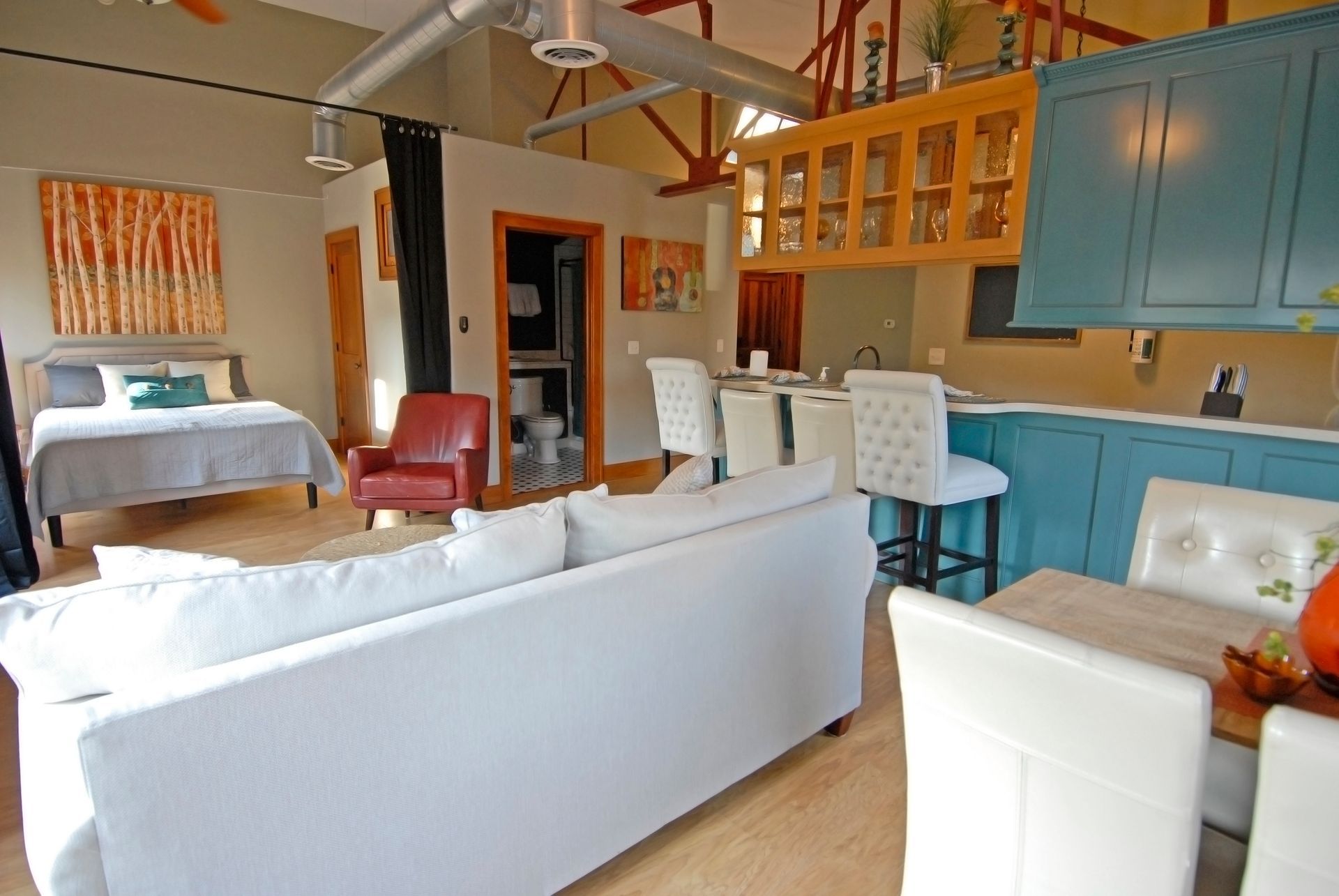 A living room with a white couch and a bed