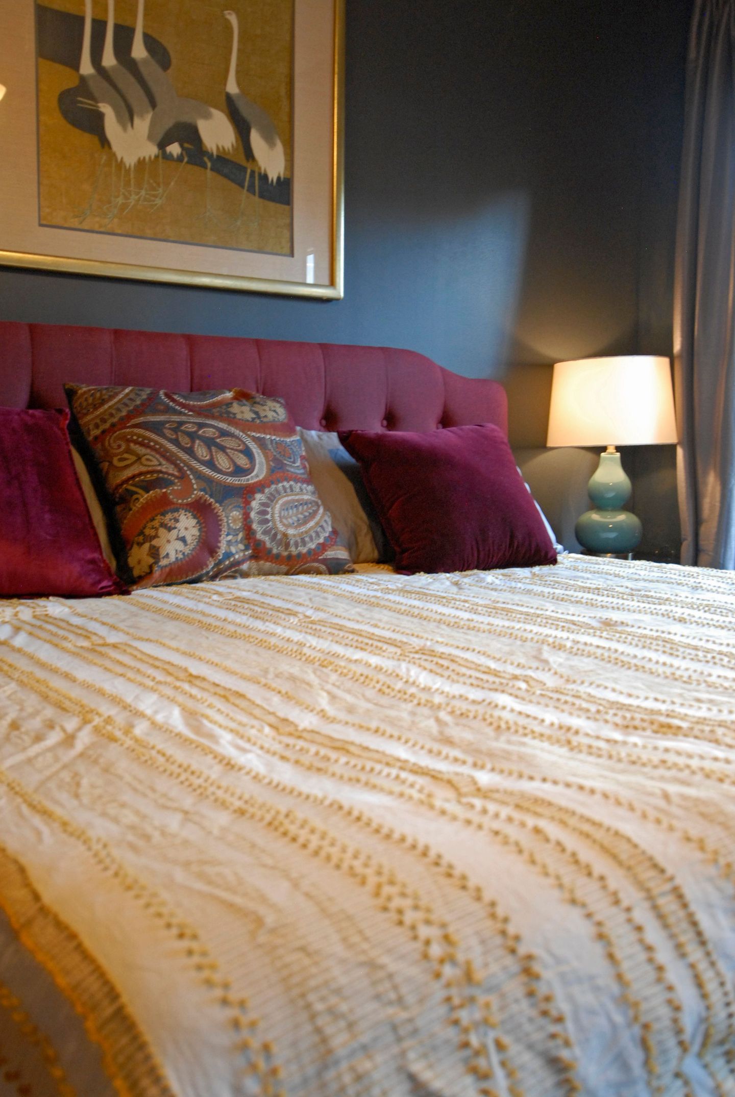 A bed with pillows and a lamp in a bedroom