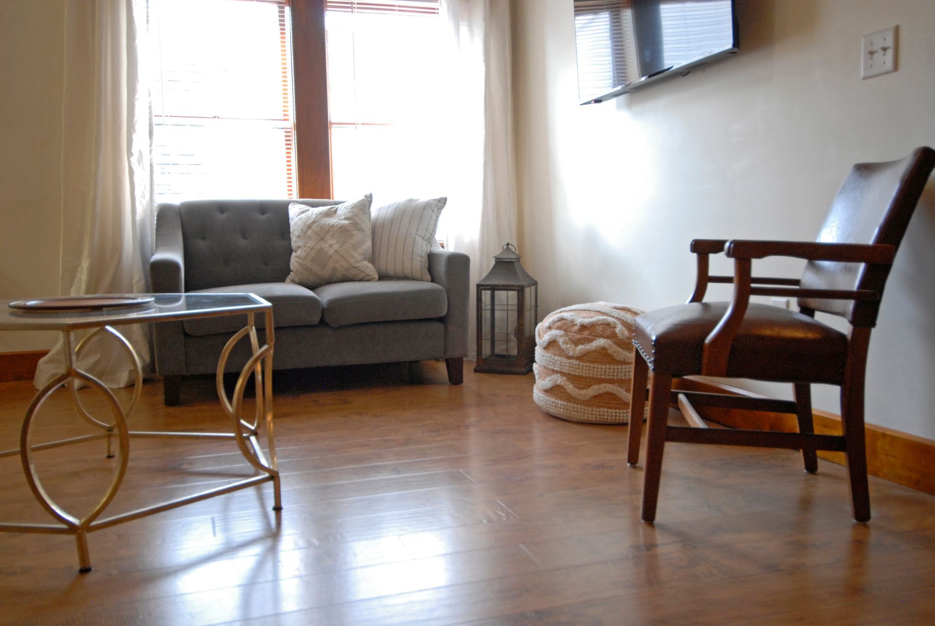 A living room with a couch , chair , coffee table and television.