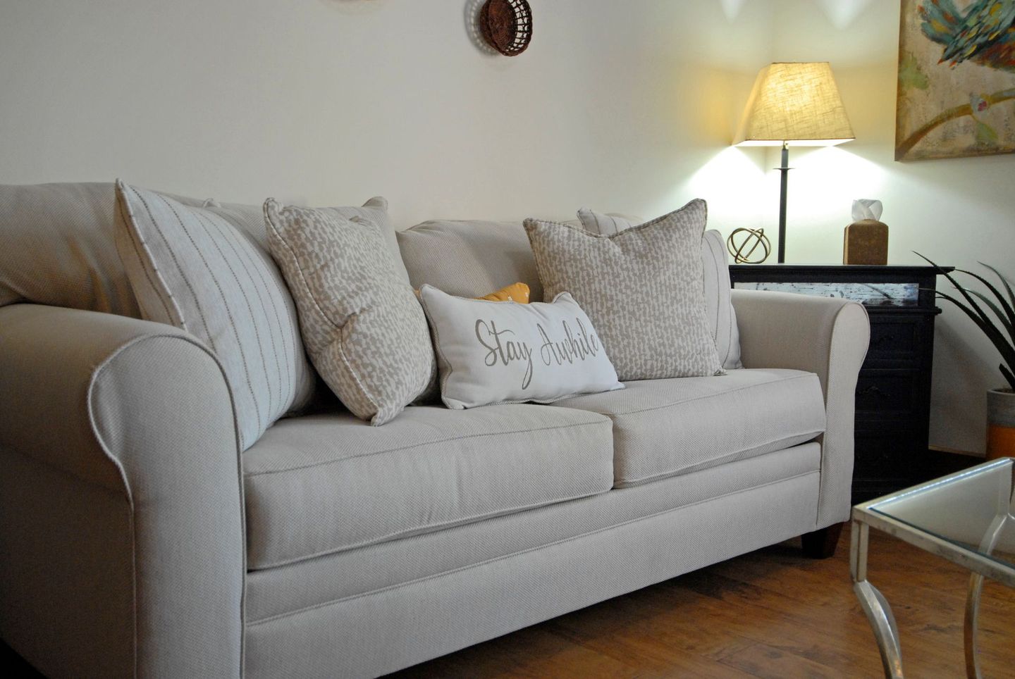 A couch in a living room with a pillow that says stay wild