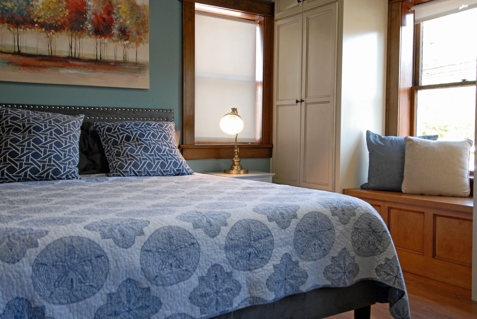 A bedroom with a bed and a window seat