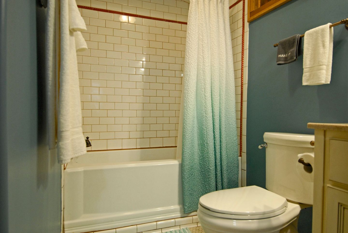 A bathroom with a toilet , bathtub and shower curtain.