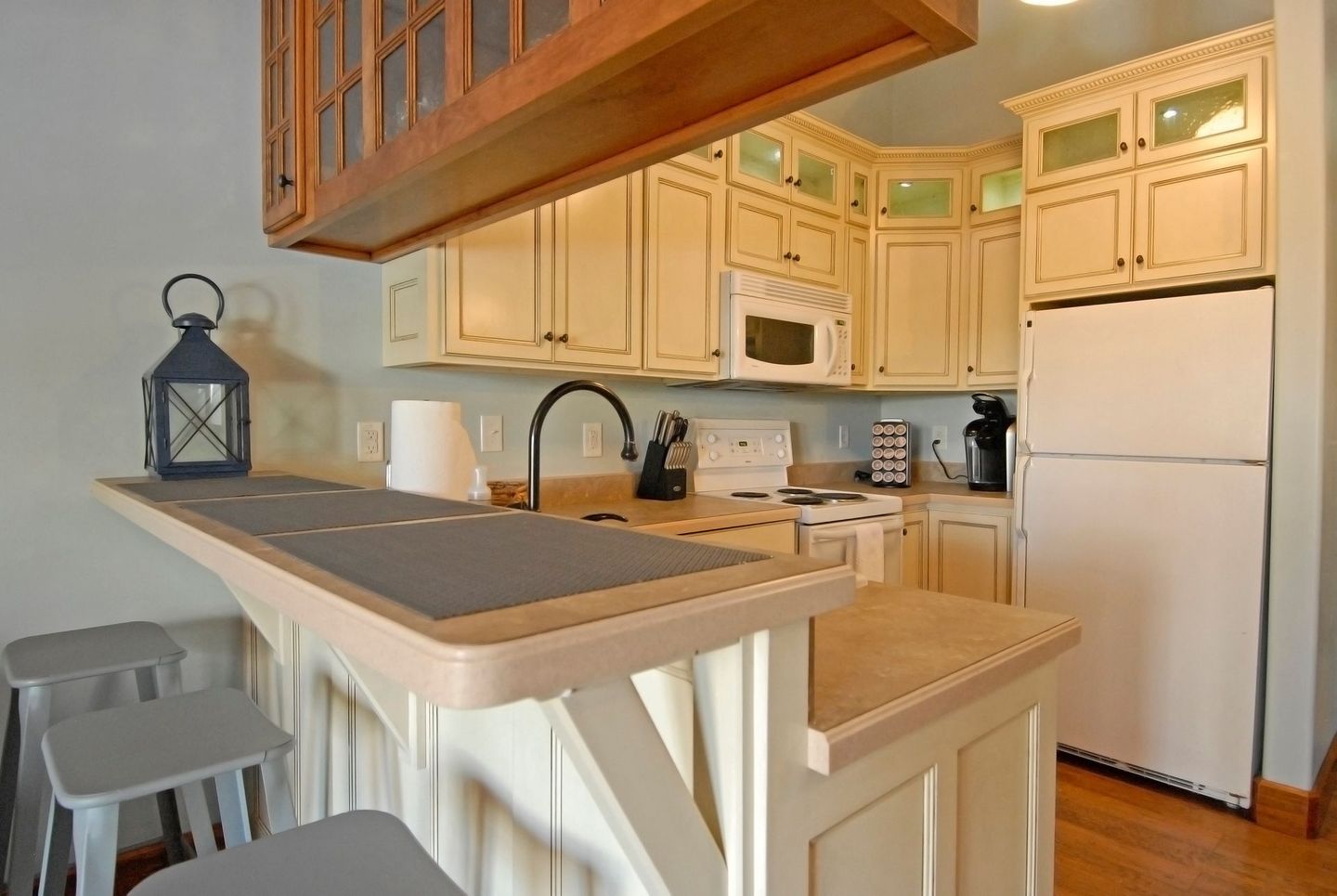 A kitchen with white cabinets and a white refrigerator