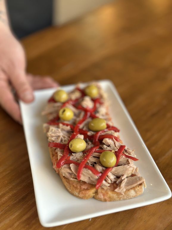 Plato de cerdo frito sazonado con rebanadas de pan.