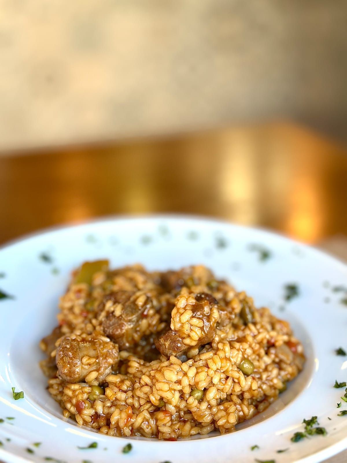 Trozos de papa dorados en un recipiente azul, cubiertos con salsa rosa y guarnición de pimiento rojo.