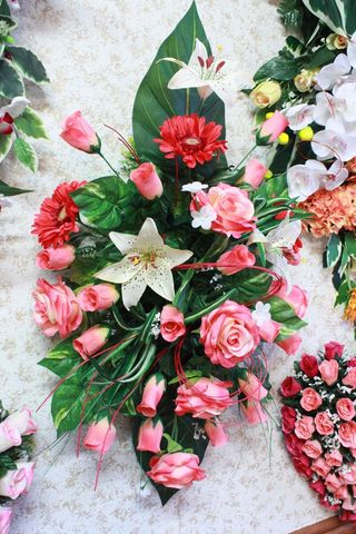 Couronnes de fleurs roses et blanches assorties avec des feuilles vertes disposées sur un fond clair
