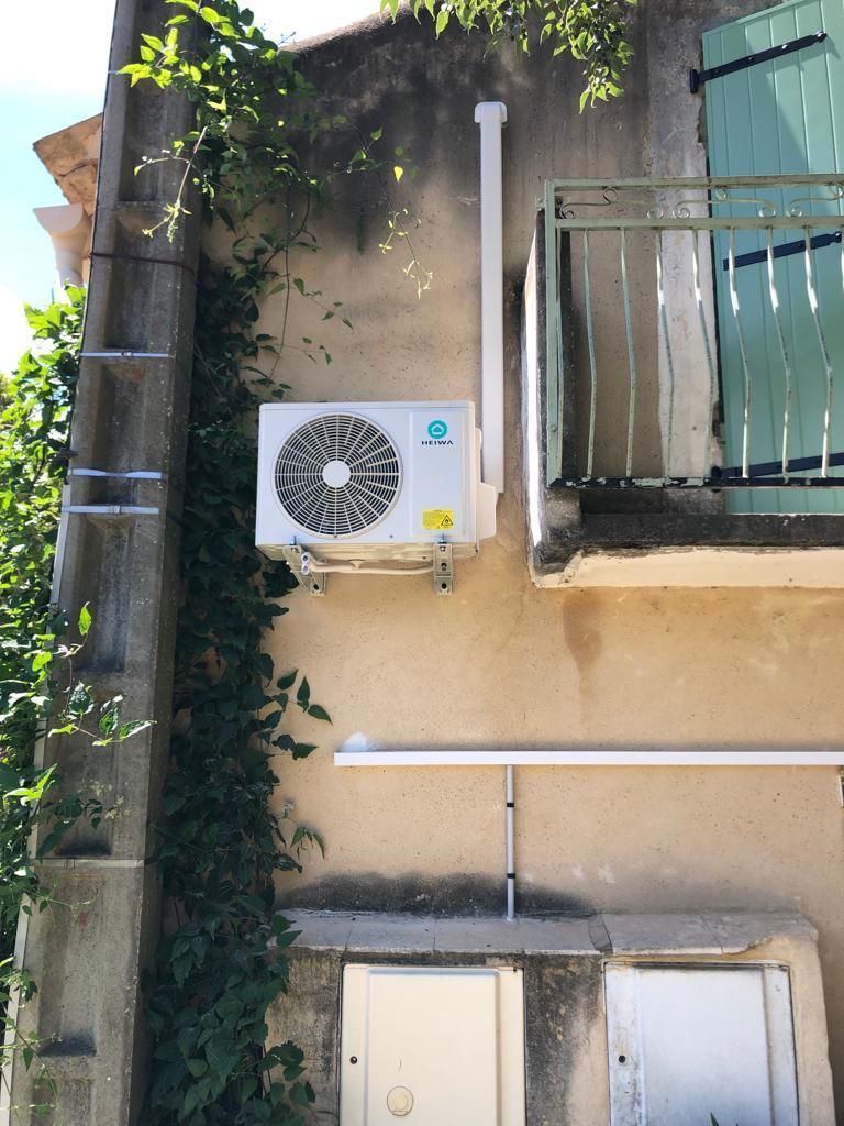 Une unité de pompe à chaleur murale en extérieur de maison.