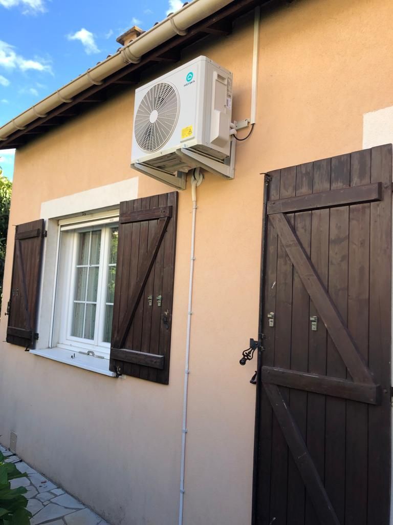 Une unité de PAC en extérieur sur la façade de maison.