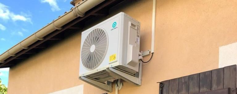 Une PAC sous la toiture extérieure d'une maison.