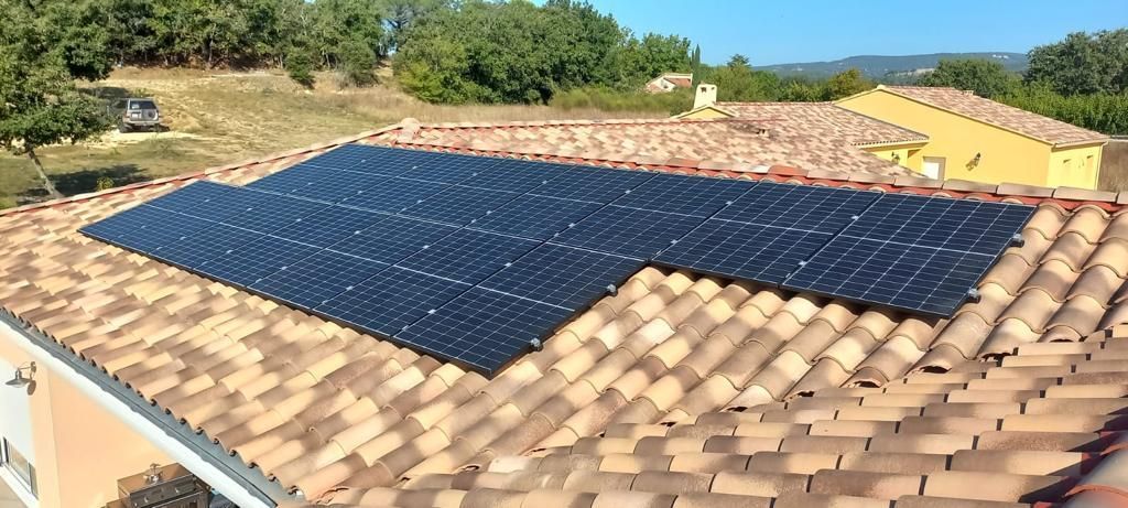 Plusieurs panneaux photovoltaïques sur un toit de maison méridionnale.
