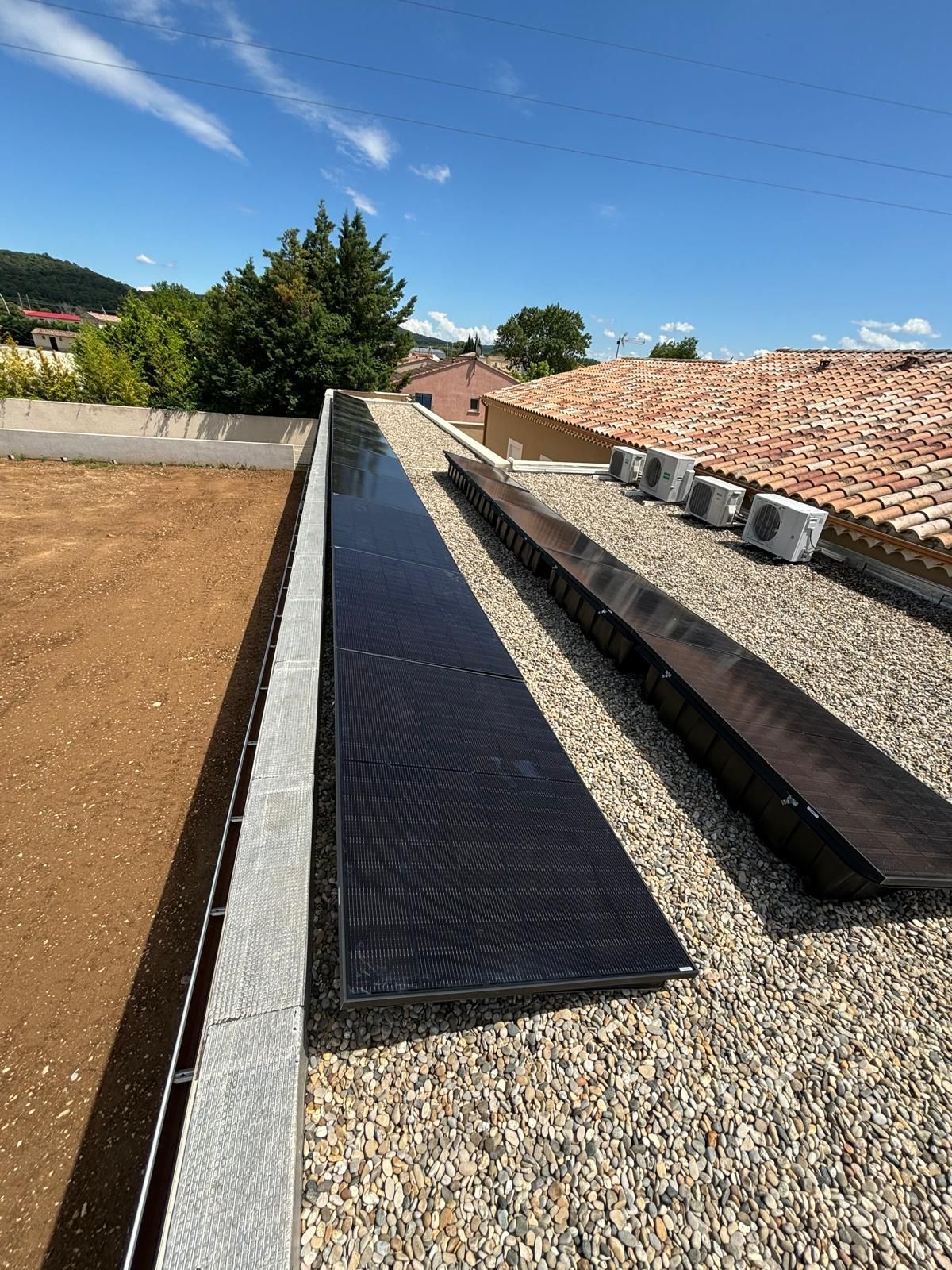 Panneaux solaires et pompes à chaleur sur un toit plat.