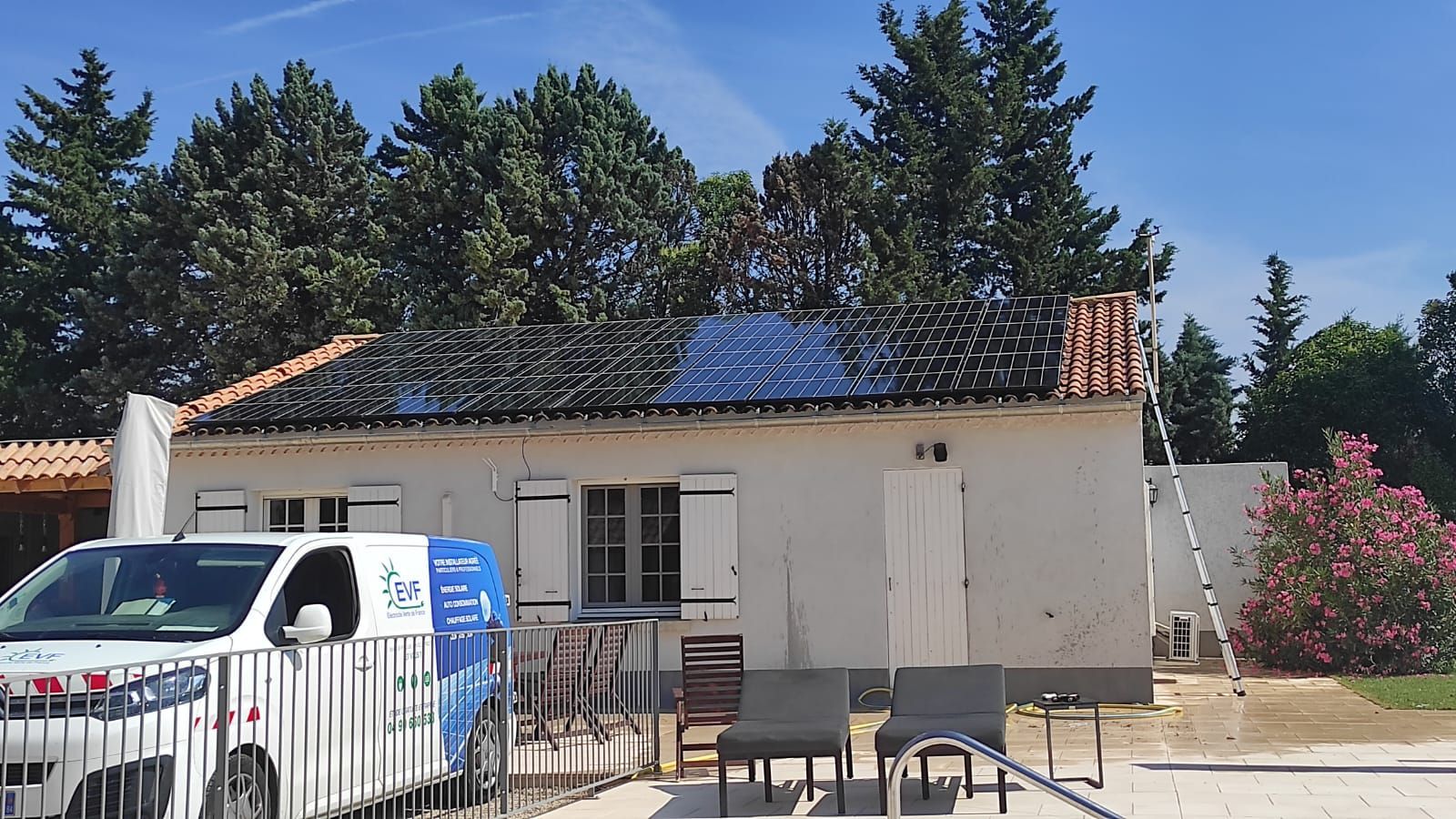 Le véhicule d'intervention estampillé EVF devant une maison avec panneaux solaires sur la toiture.