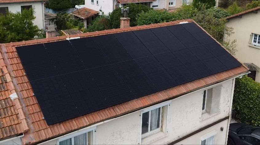 Plusieurs panneaux photovoltaïques sur un toit de maison en tuiles plates.