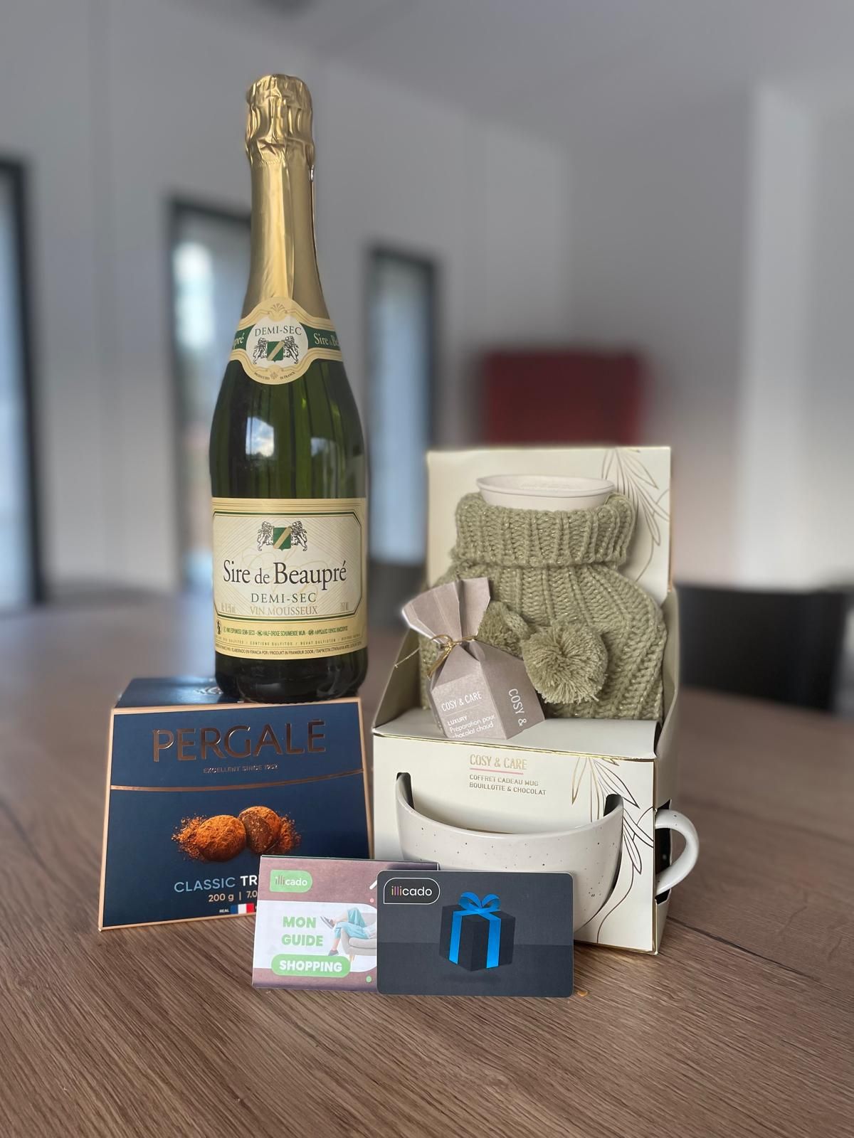 Les cadeaux de parrainage avec une bouteille de vin pétillant, un mug, des truffes et une carte-cadeau.