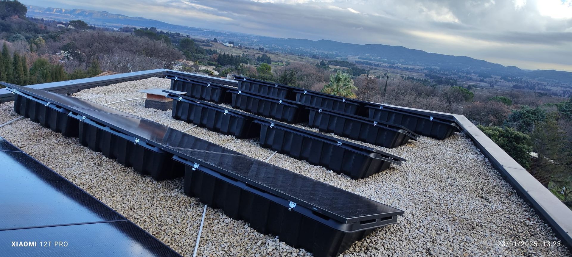Plusieurs panneaux photovoltaïques sur un toit plat de maison.