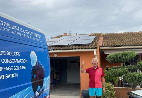 Un client levant le pouce à côté du véhicule d'intervention de EVF, en fond des panneaux solaires sur une toiture.