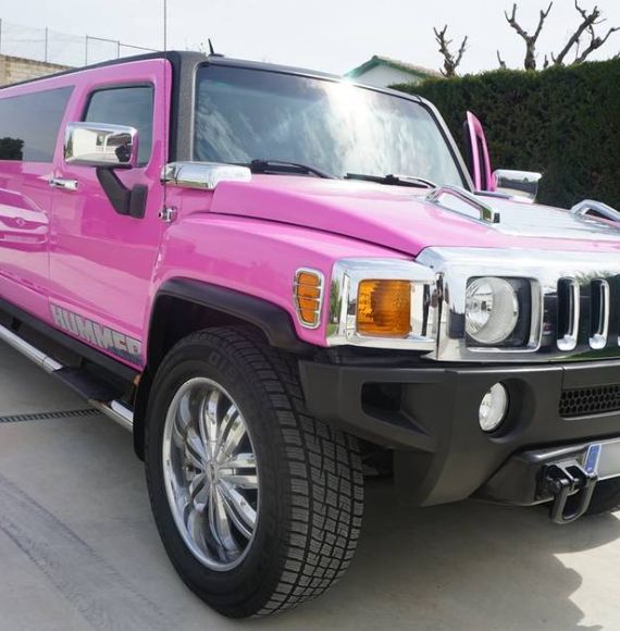Un Hummer rosa está estacionado en un estacionamiento.