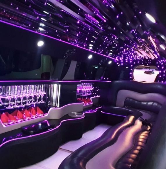 El interior de una limusina con luces moradas en el techo.