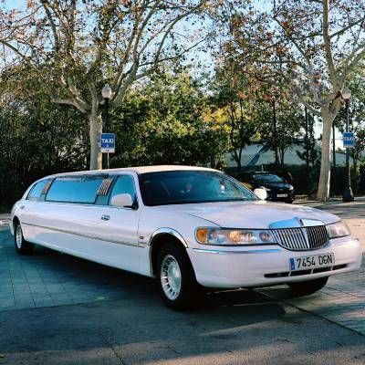 Una limusina blanca está estacionada al costado de la carretera.
