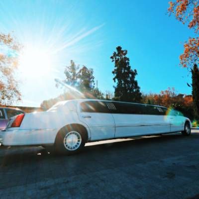 Una limusina blanca está estacionada al costado de la carretera.