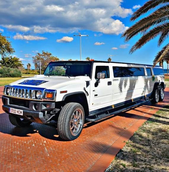Un Hummer blanco está estacionado al costado de la carretera.