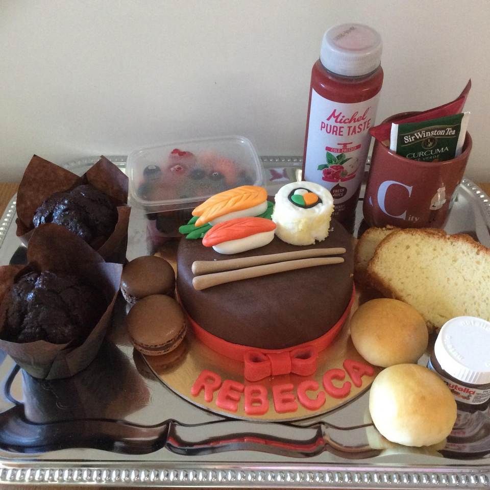 Un vassoio di cibo con una torta con scritto rebecca sopra