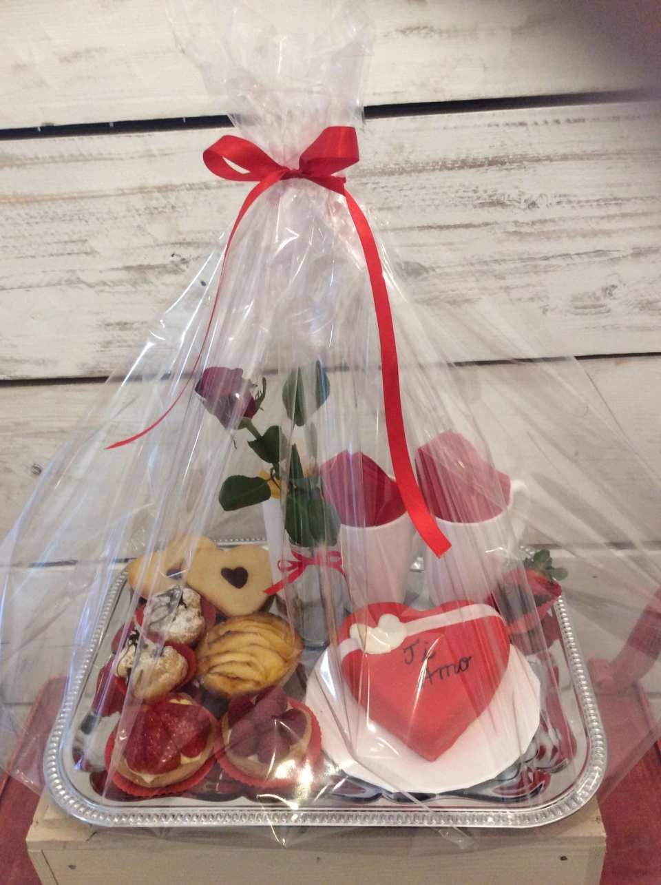 Un vassoio pieno di cupcakes, biscotti e una torta a forma di cuore.