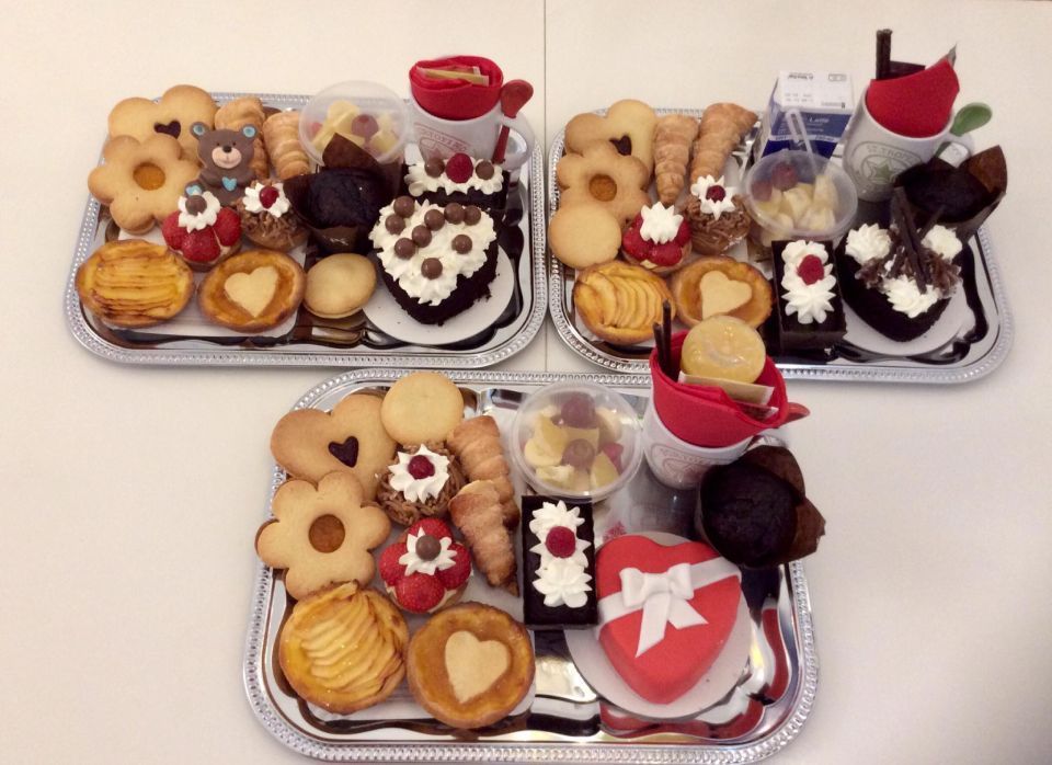 Tre vassoi d'argento pieni di diversi tipi di biscotti e cupcake