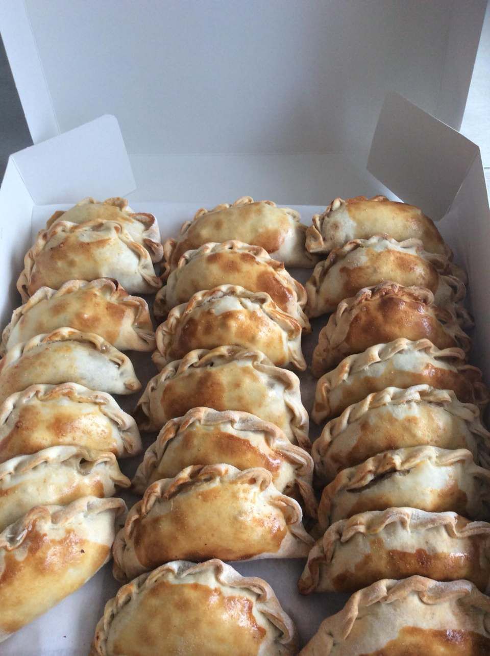 Una scatola piena di dolci è appoggiata su un tavolo.